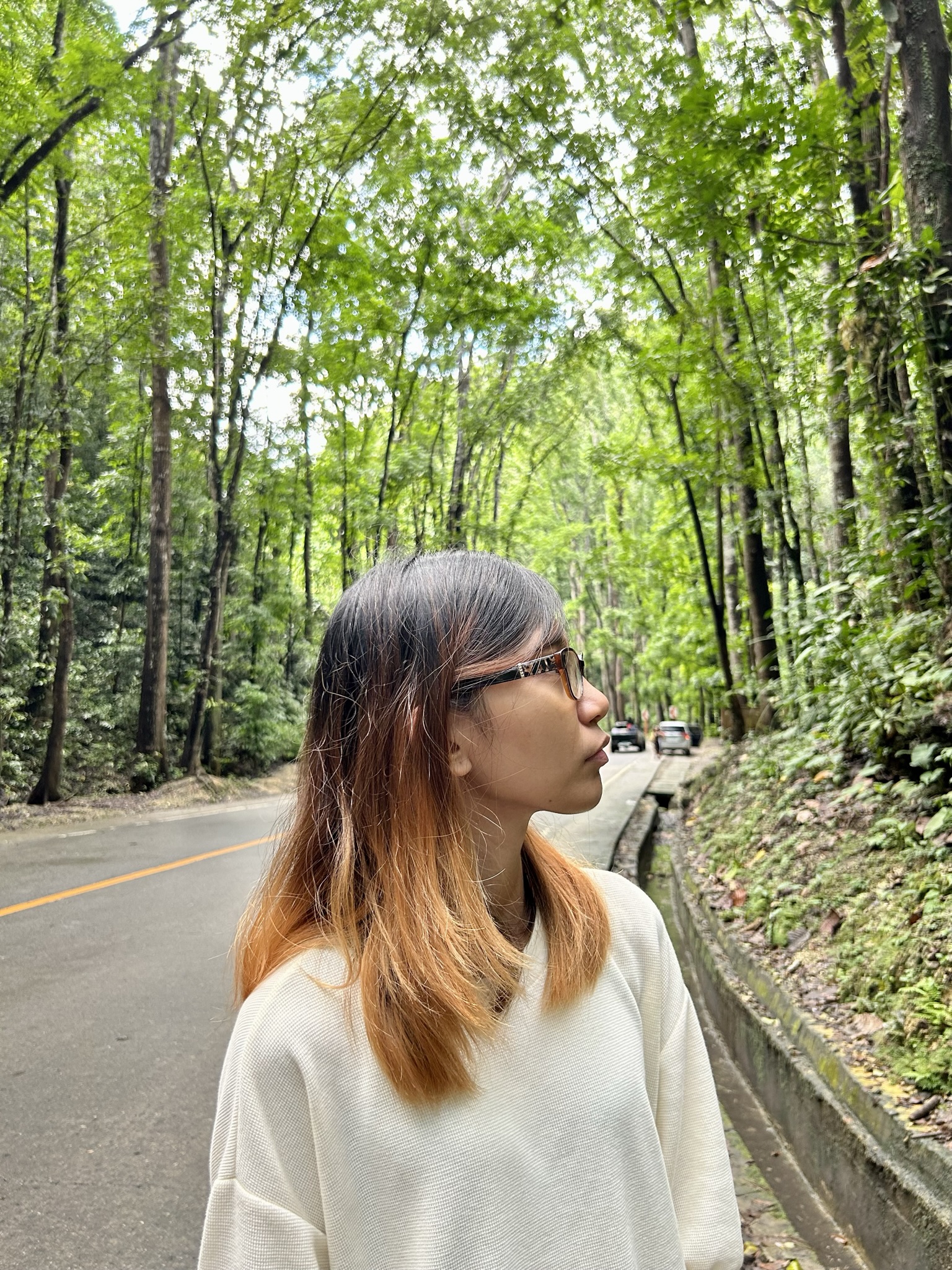 Woman facing sideways in the man-made forest.